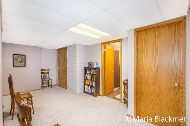 sitting room featuring carpet and a paneled ceiling
