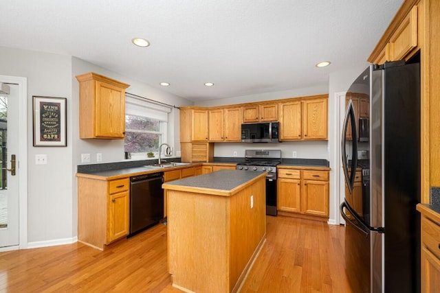 kitchen featuring a sink, a center island, light wood-style floors, and stainless steel appliances
