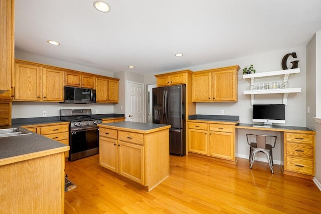 kitchen with black fridge with ice dispenser, dark countertops, stainless steel gas range, and light wood-type flooring