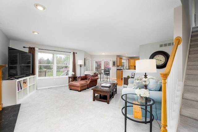living area with light carpet, stairs, recessed lighting, baseboards, and visible vents