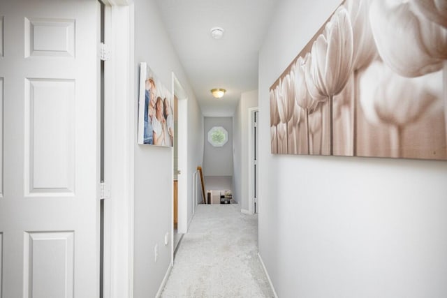 corridor featuring baseboards, carpet flooring, and an upstairs landing