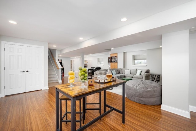 living area with baseboards, recessed lighting, wood finished floors, and stairway