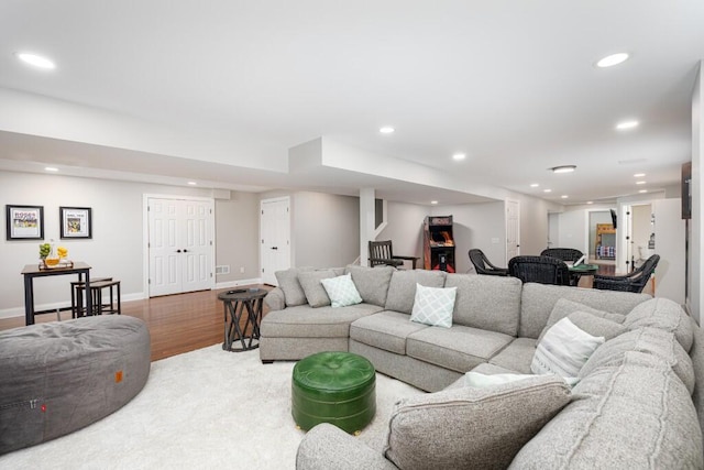 living area featuring baseboards, recessed lighting, wood finished floors, and stairs