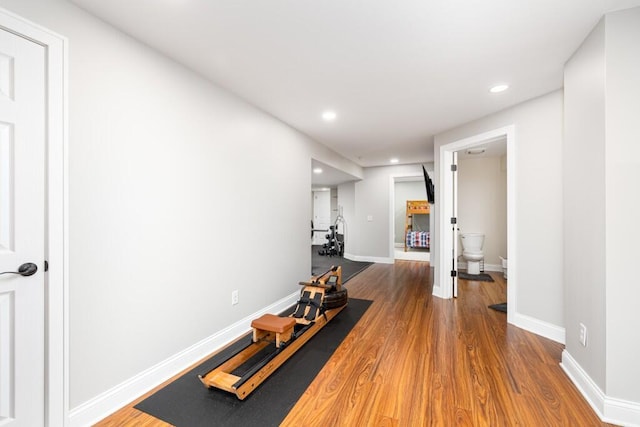 exercise room with baseboards, recessed lighting, and wood finished floors