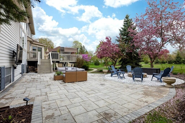view of patio featuring an outdoor living space with a fire pit, a wooden deck, and stairway