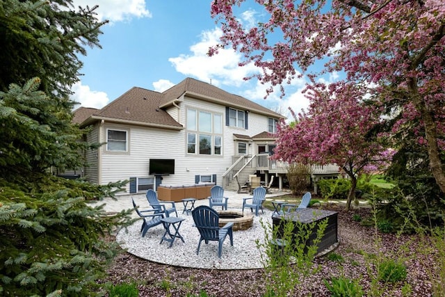 back of property featuring a deck, a patio, roof with shingles, stairs, and an outdoor fire pit