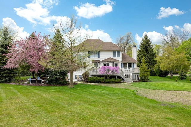 back of property with a lawn, a wooden deck, and a chimney