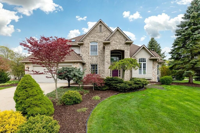 view of front facade with a garage, stone siding, a front yard, and concrete driveway