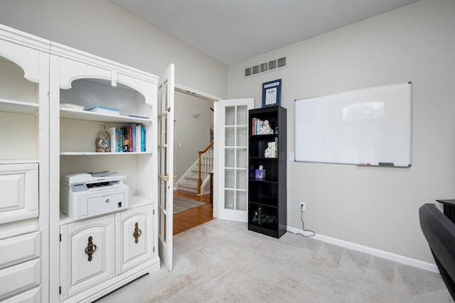 office area featuring visible vents, baseboards, and light colored carpet