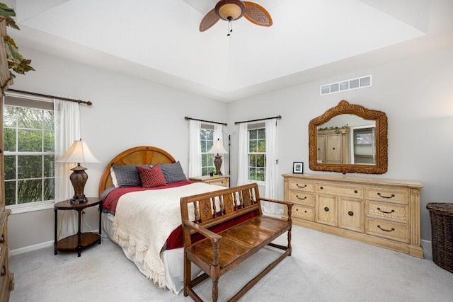 bedroom featuring visible vents, baseboards, ceiling fan, and light colored carpet