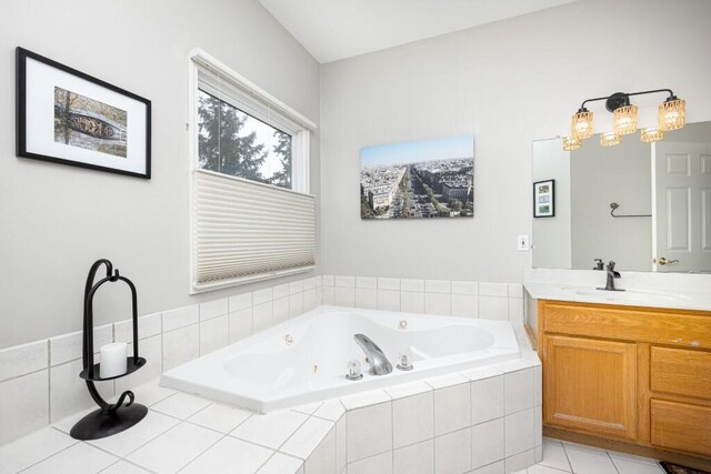 full bathroom featuring a jetted tub, vanity, and tile patterned floors