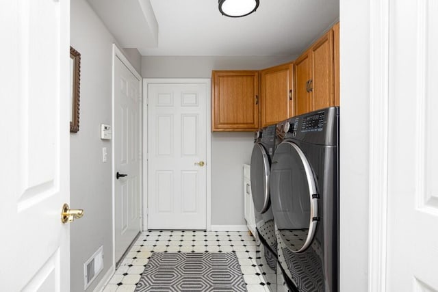 washroom featuring separate washer and dryer, cabinet space, baseboards, and visible vents