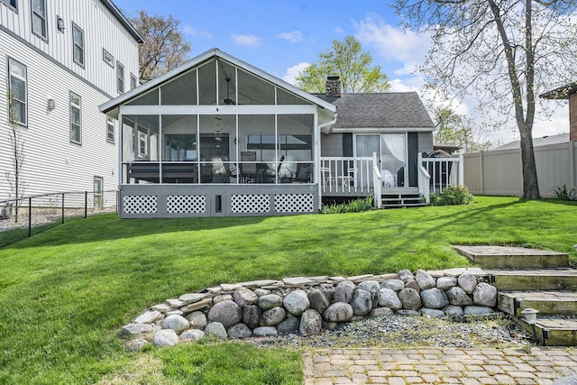 23848 Brady St, Edwardsburg, MI 49112 - back of house featuring a wooden deck, a fenced backyard, a chimney, a sunroom, and a lawn