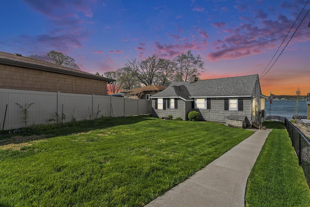 23848 Brady St, Edwardsburg, MI 49112 - view of front facade with a shingled roof, a fenced backyard, and a front lawn