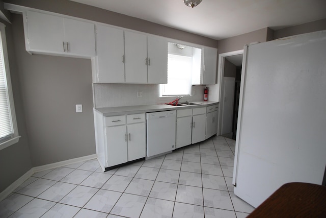 kitchen featuring tasteful backsplash, a sink, light countertops, white cabinets, and white appliances