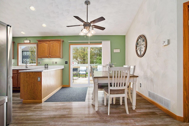 dining area with a ceiling fan, baseboards, visible vents, and wood finished floors