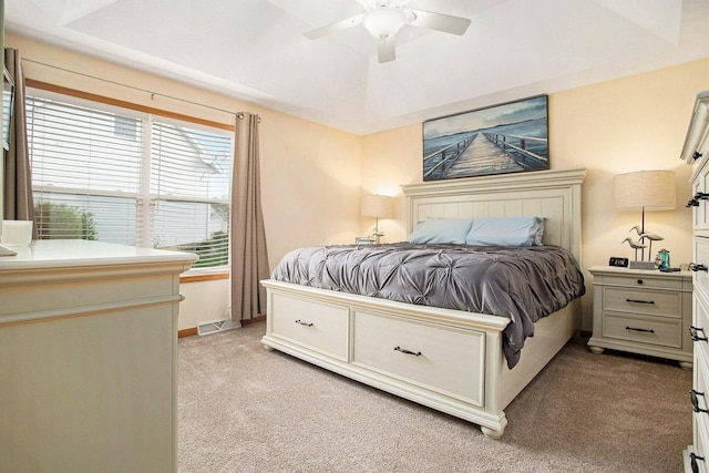 bedroom with baseboards, visible vents, a ceiling fan, and light colored carpet