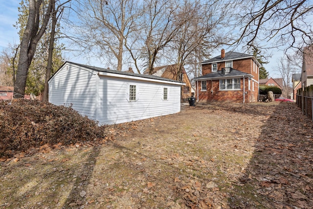 17193 Pierson St, Detroit, MI 48219 - back of house featuring brick siding, fence, a chimney, and an outbuilding