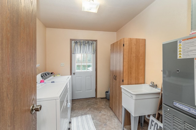 clothes washing area with laundry area, a sink, heating unit, and washer and dryer