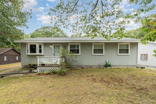 single story home with roof with shingles and a front yard