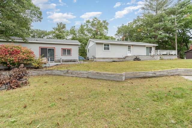 rear view of property featuring a lawn, a wooden deck, and central air condition unit