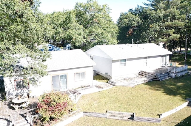 rear view of house with a wooden deck and a yard