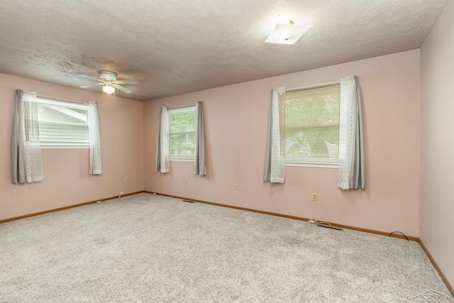 carpeted empty room featuring a textured ceiling, ceiling fan, and baseboards