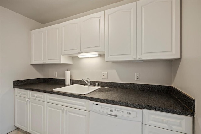 kitchen with white cabinets, white dishwasher, dark countertops, and a sink