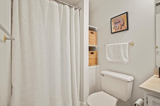 bathroom with vanity, curtained shower, and toilet
