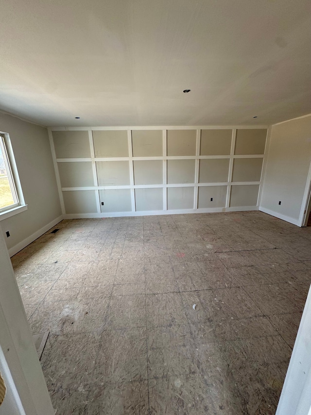 unfurnished room with baseboards