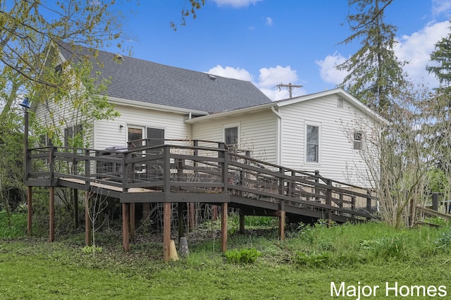 back of house featuring a shingled roof and a wooden deck