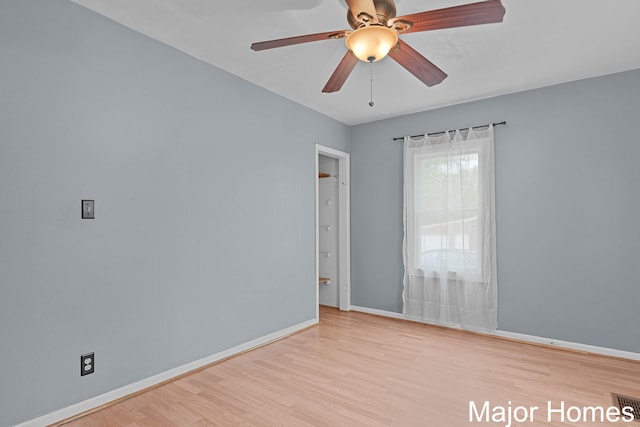 empty room with baseboards, a ceiling fan, and wood finished floors
