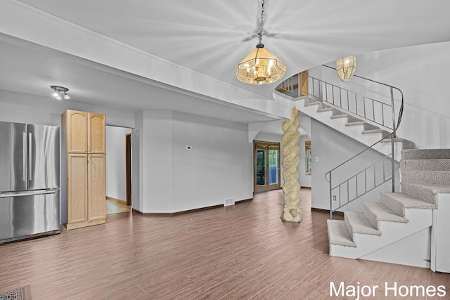 interior space featuring visible vents, stairs, wood finished floors, and a chandelier