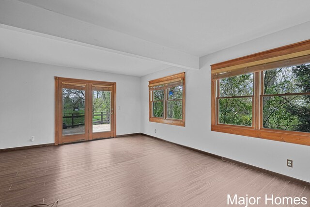 unfurnished room featuring baseboards and wood finished floors