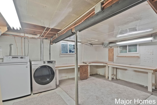 laundry room featuring concrete block wall, laundry area, and washing machine and dryer