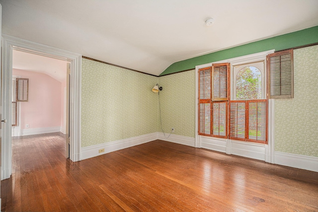 unfurnished room with a healthy amount of sunlight, lofted ceiling, and hardwood / wood-style floors