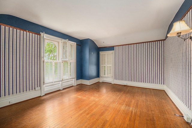 empty room featuring baseboards and hardwood / wood-style floors