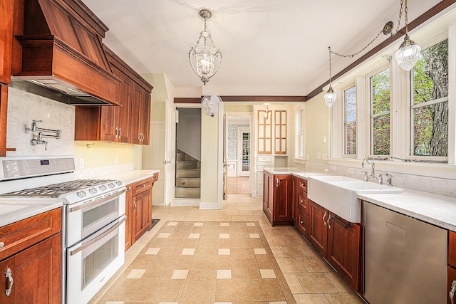 kitchen featuring double oven range, pendant lighting, stainless steel dishwasher, a sink, and premium range hood