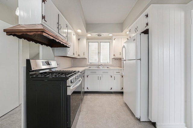 kitchen featuring white cabinets, a sink, gas stove, light countertops, and freestanding refrigerator