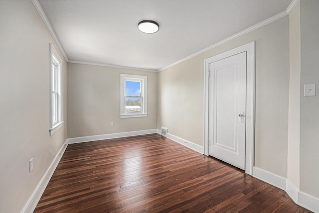 empty room featuring crown molding, baseboards, visible vents, and dark wood finished floors