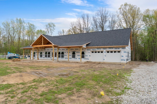 property under construction with a garage, a shingled roof, and driveway