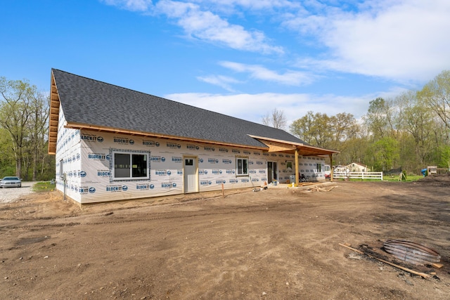 exterior space featuring roof with shingles and fence