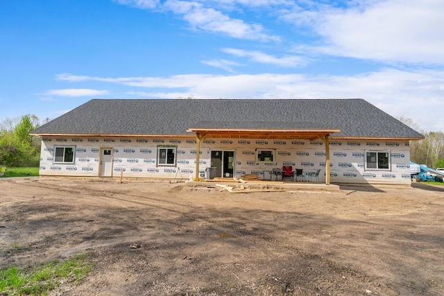 rear view of house with a shingled roof