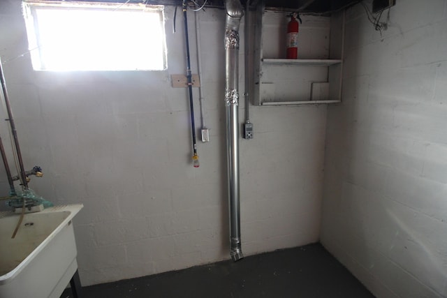 below grade area with a sink and concrete block wall