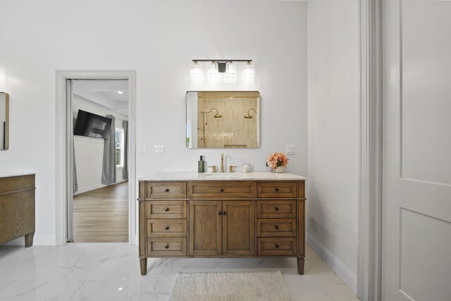 full bath with baseboards, marble finish floor, and vanity