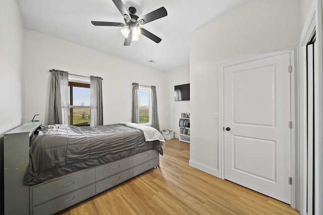 bedroom featuring baseboards, a ceiling fan, and light wood-type flooring