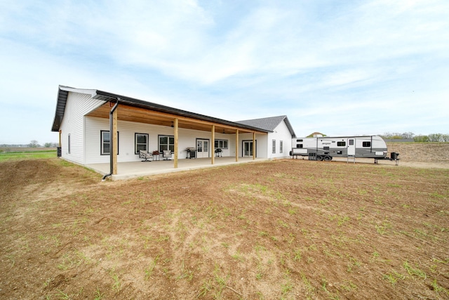 rear view of house with a yard and a patio area