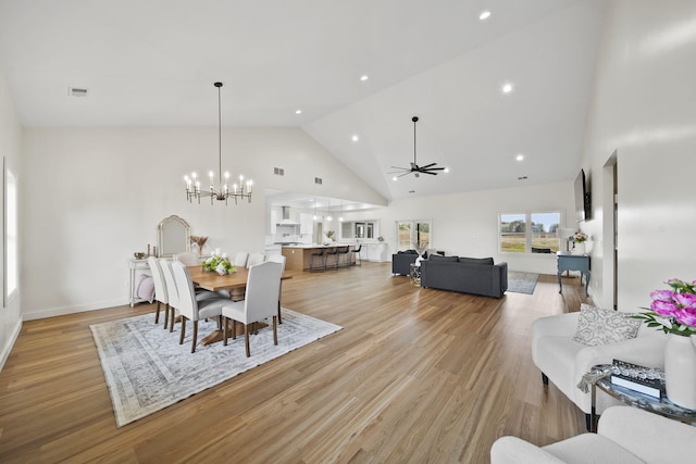 dining area with visible vents, high vaulted ceiling, ceiling fan with notable chandelier, light wood-style floors, and recessed lighting