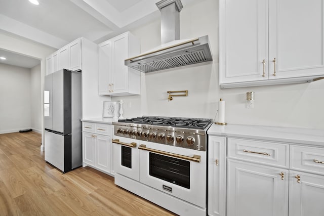 kitchen with range hood, stainless steel refrigerator with ice dispenser, light wood-type flooring, white cabinets, and double oven range