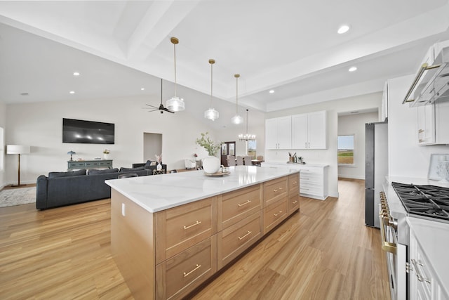 kitchen featuring light wood-style floors, white cabinetry, a ceiling fan, hanging light fixtures, and stainless steel appliances